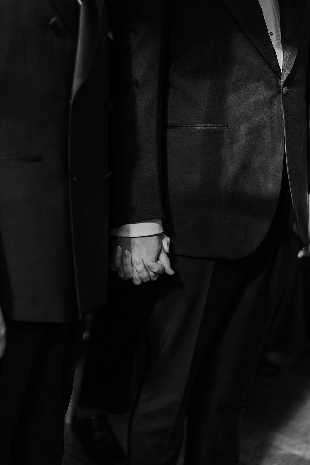 Grooms holding hands during their wedding ceremony at Middleton Lodge Estate.