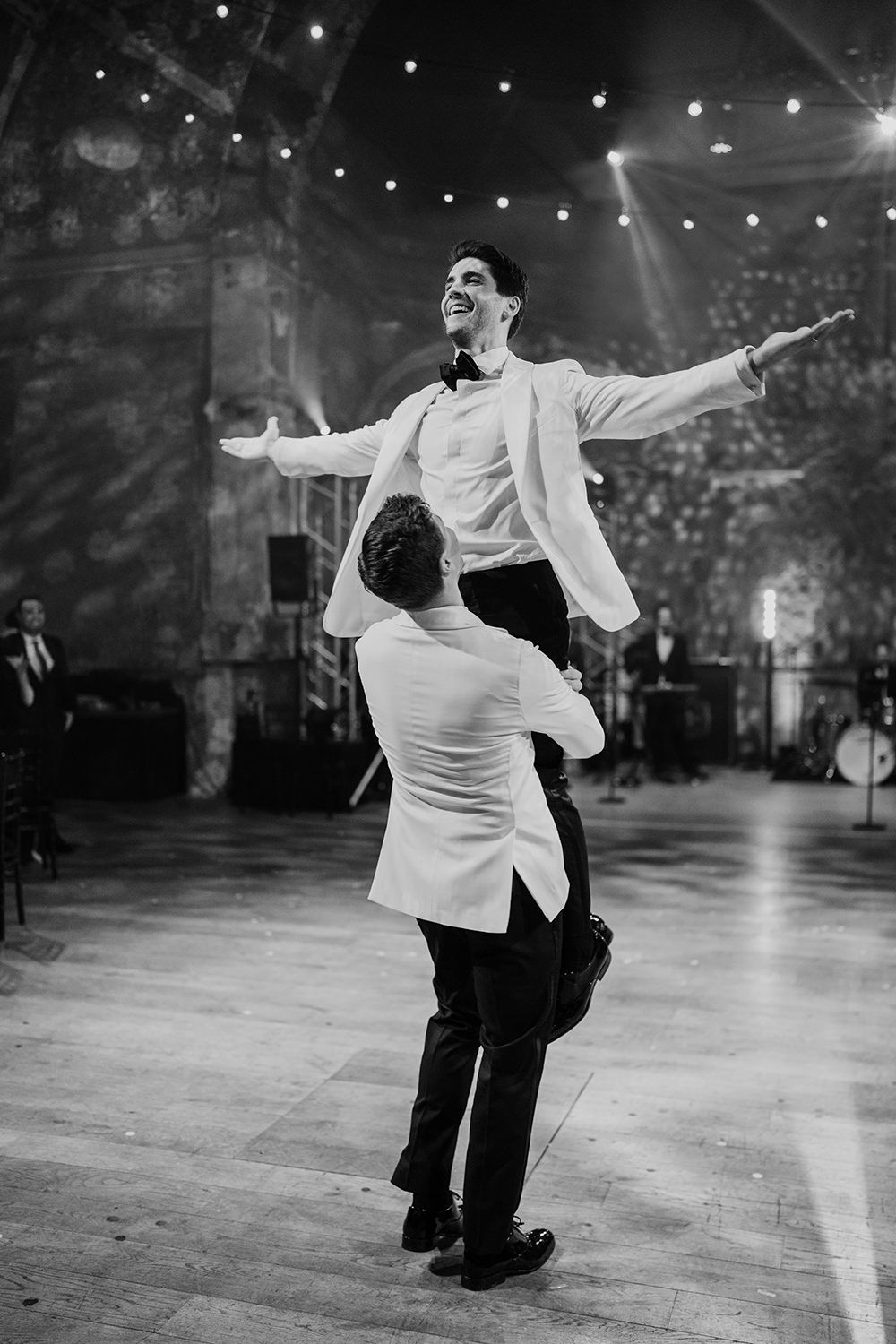 Groom lifting his husband in the air while dancing at Battersea Arts Centre.