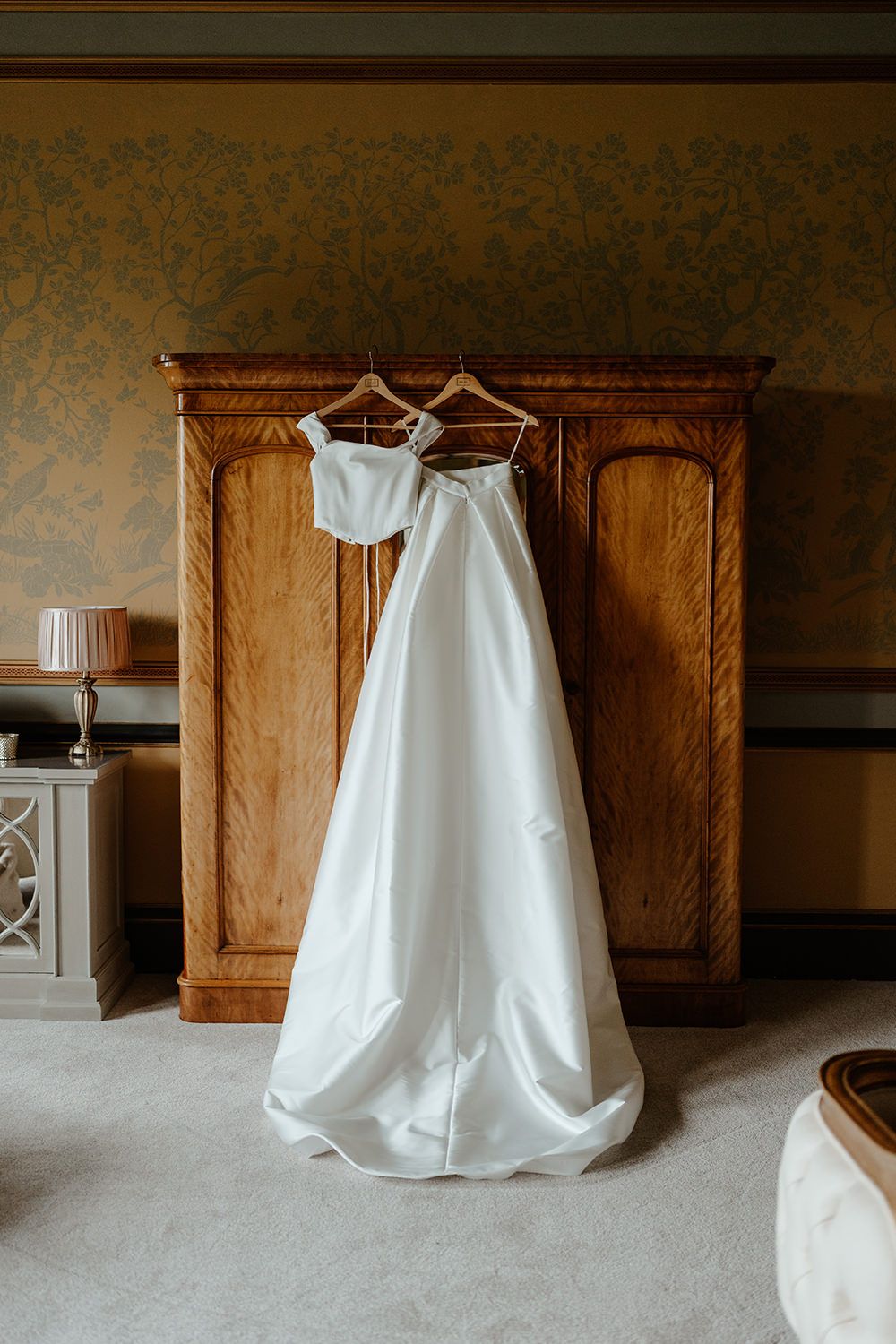 Wedding dresses hung on wooden wardrobe in Rise Hall.
