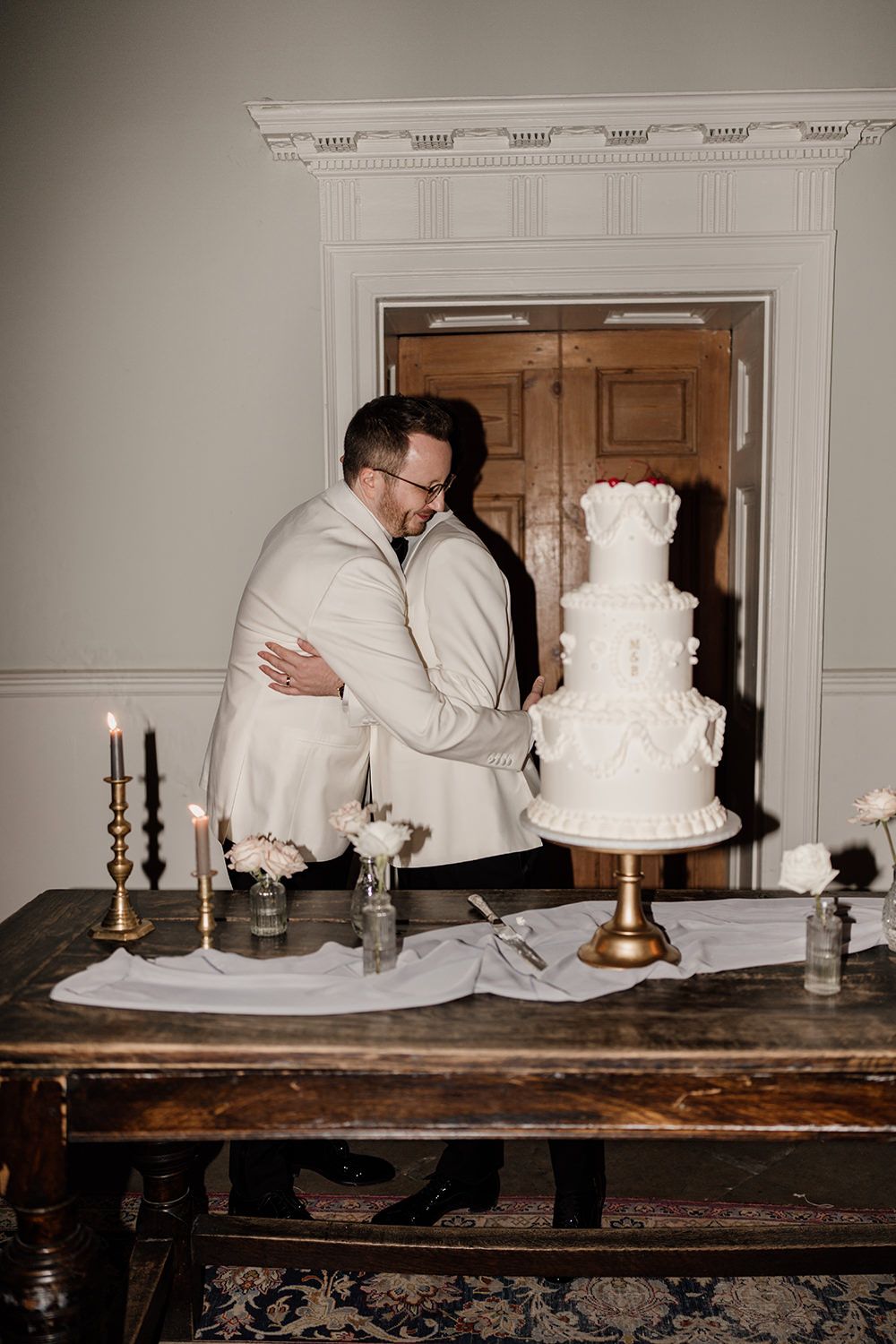 The grooms cutting into their beautifully designed wedding cake at Middleton Lodge Estate.