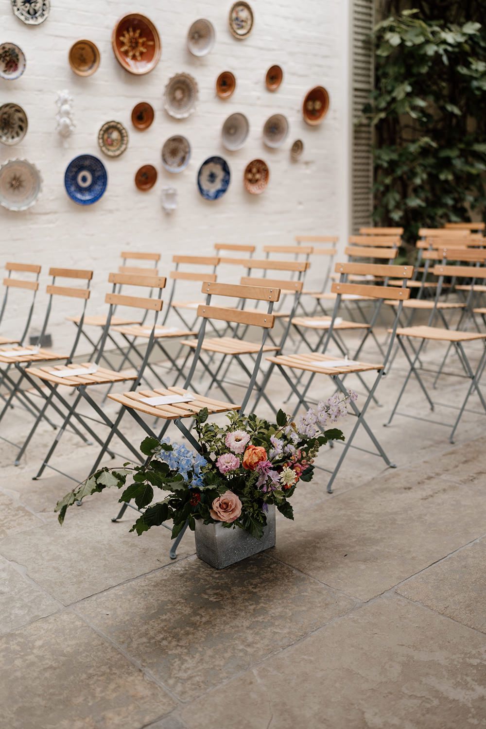 Editorial-style close-up of the bride’s colourful wedding flowers amidst the lush greenery of Kin House’s garden room.