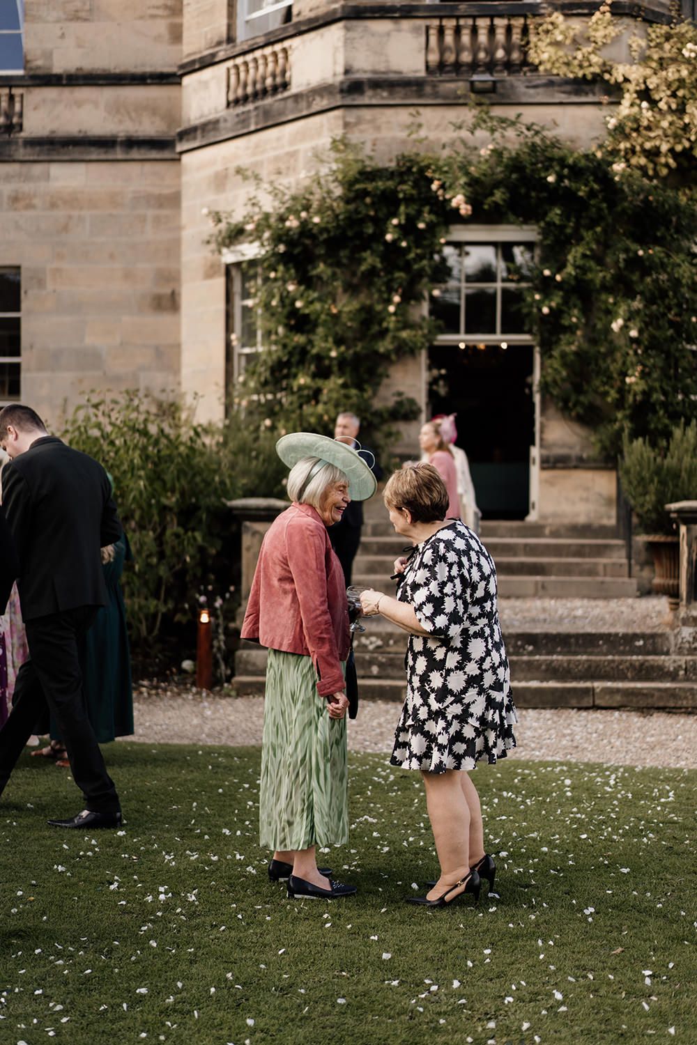 Candid wedding photography: guests enjoying cocktails on the lawn of this luxury UK wedding venue.