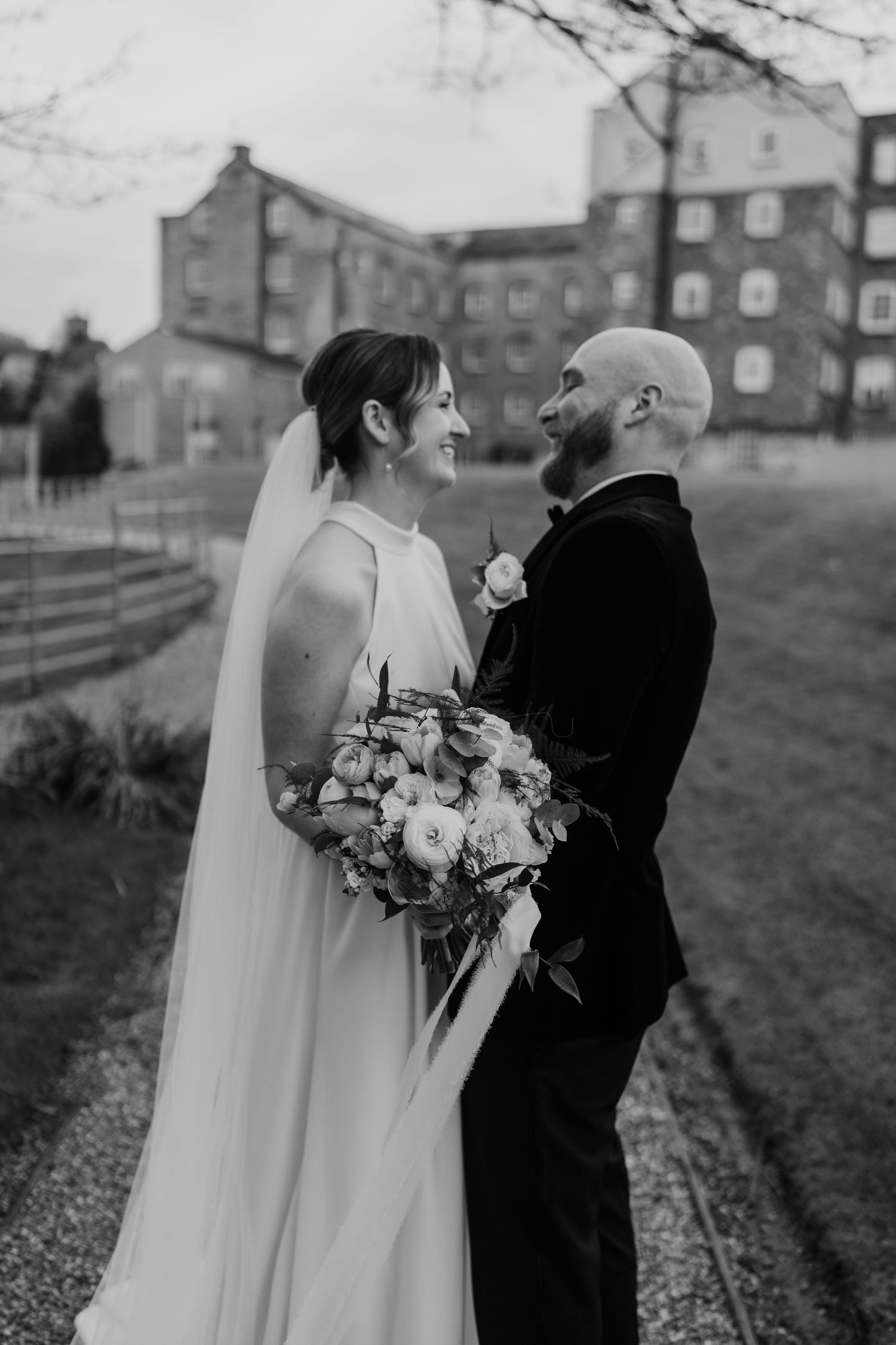 A romantic wedding portrait with historic buildings in the background.