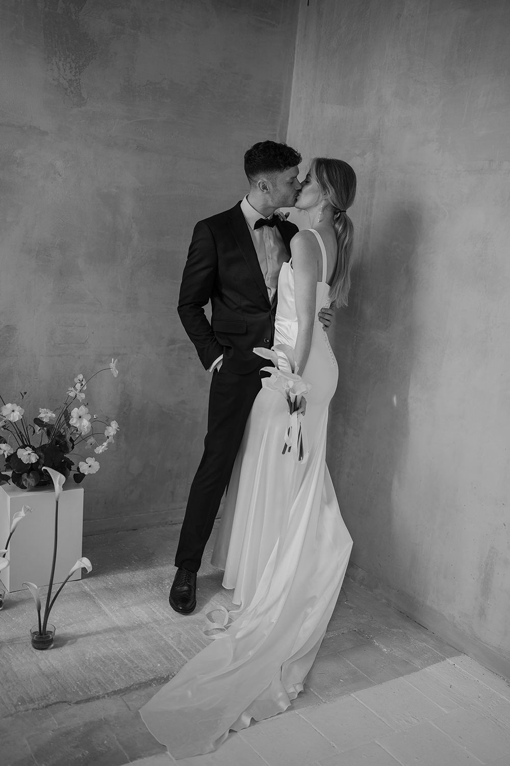 Couple kissing on their wedding day in black and white at Els Comellars.