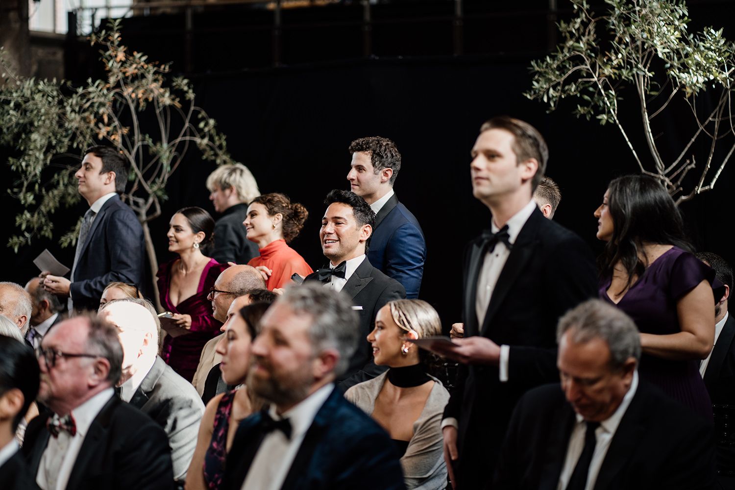 Wedding guests standing singing during the ceremony at Battersea Arts Centre.