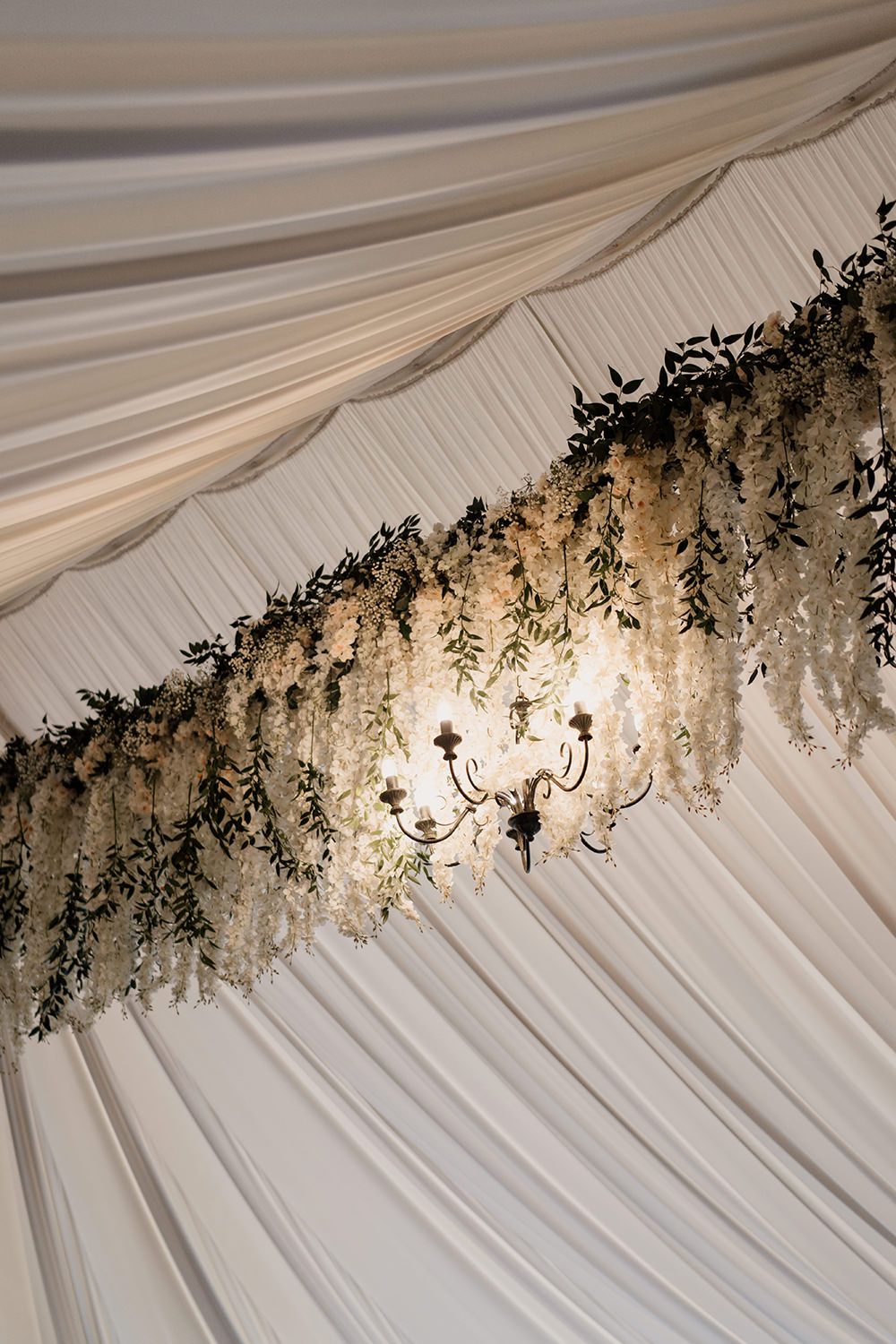 White statement draping with green hanging florals in the marquee at Middleton Lodge Estate.