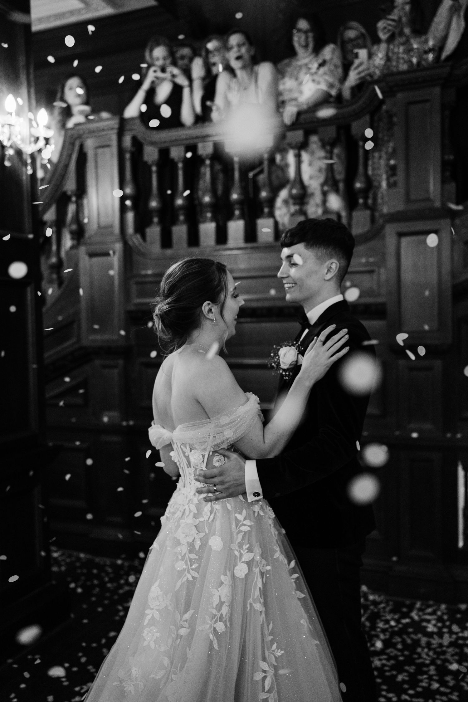 Bride and grooms first dance while family throw confetti around them at Bourton Hall.