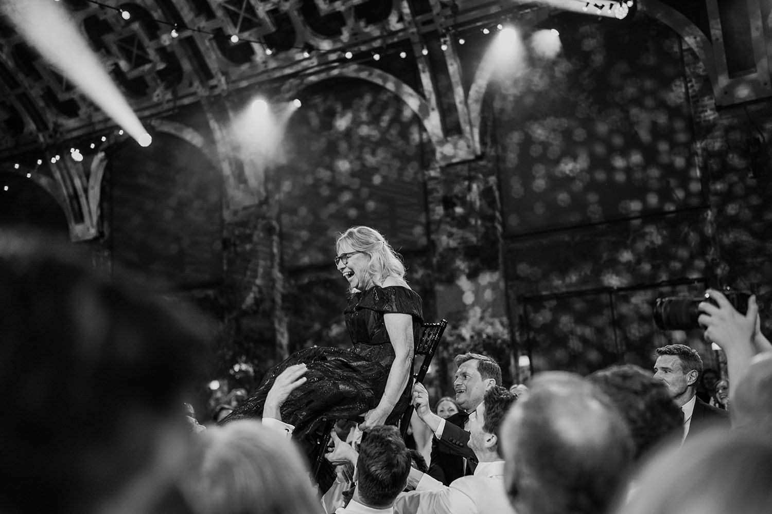 Grooms mother being raised on a chair during Hora at their wedding.