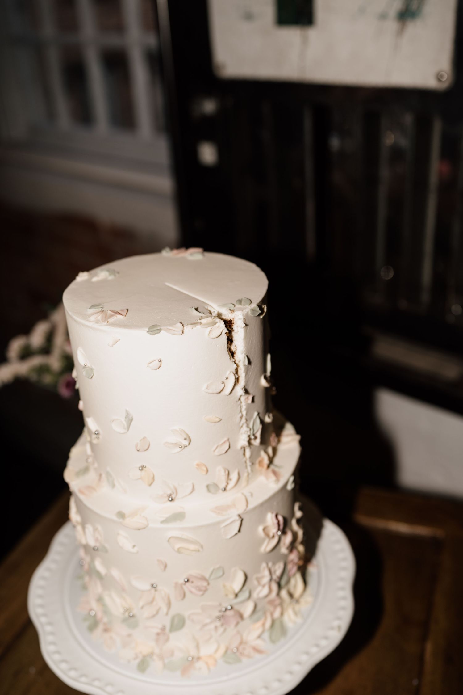 Elegant two-tiered white wedding cake with textured frosting and delicate floral details.