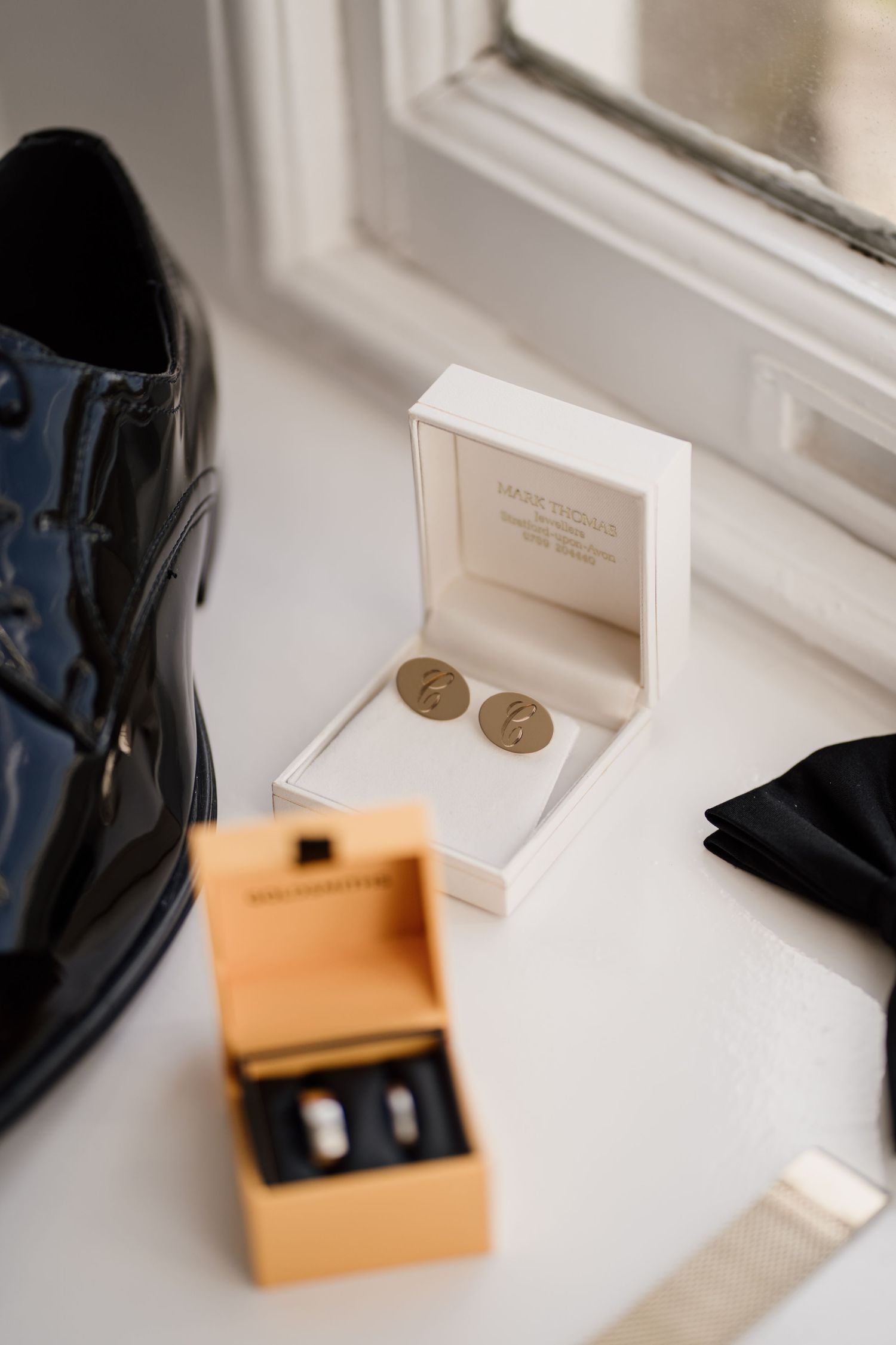 Grooms wedding day details featuring shoes, rings, watch and bow tie.
