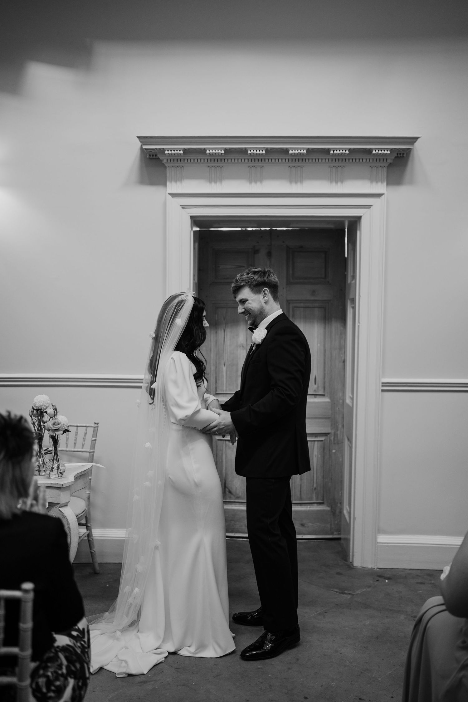 Bride and groom holding hands during their wedding ceremony.