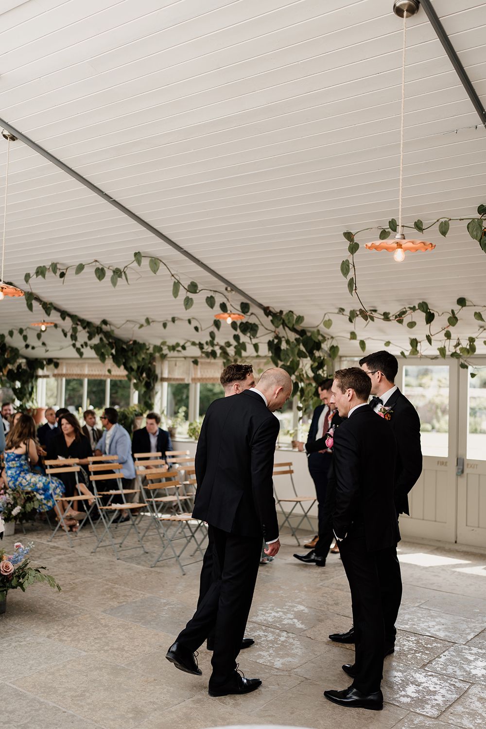 Groomsmen surrounded by greenery and natural light in The Garden Room at Kin House.