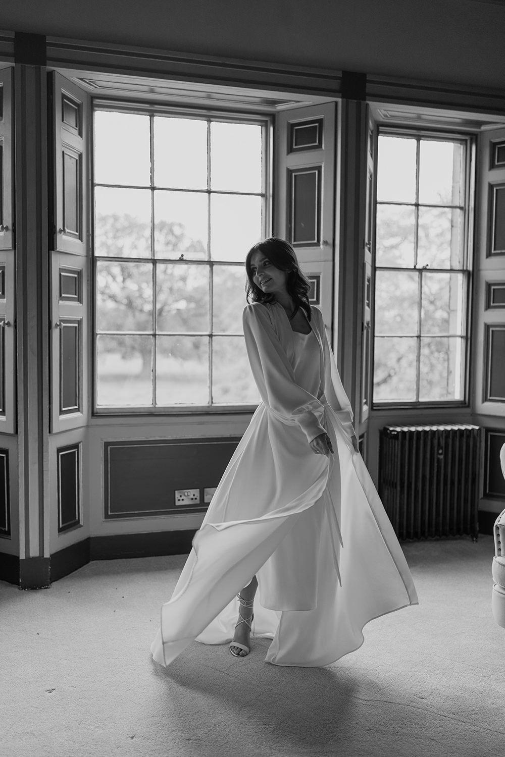 Bride dancing in her morning gown in black and white at Rise Hall.