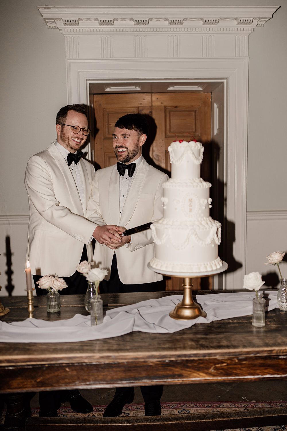 The grooms cutting into their beautifully designed wedding cake at Middleton Lodge Estate.