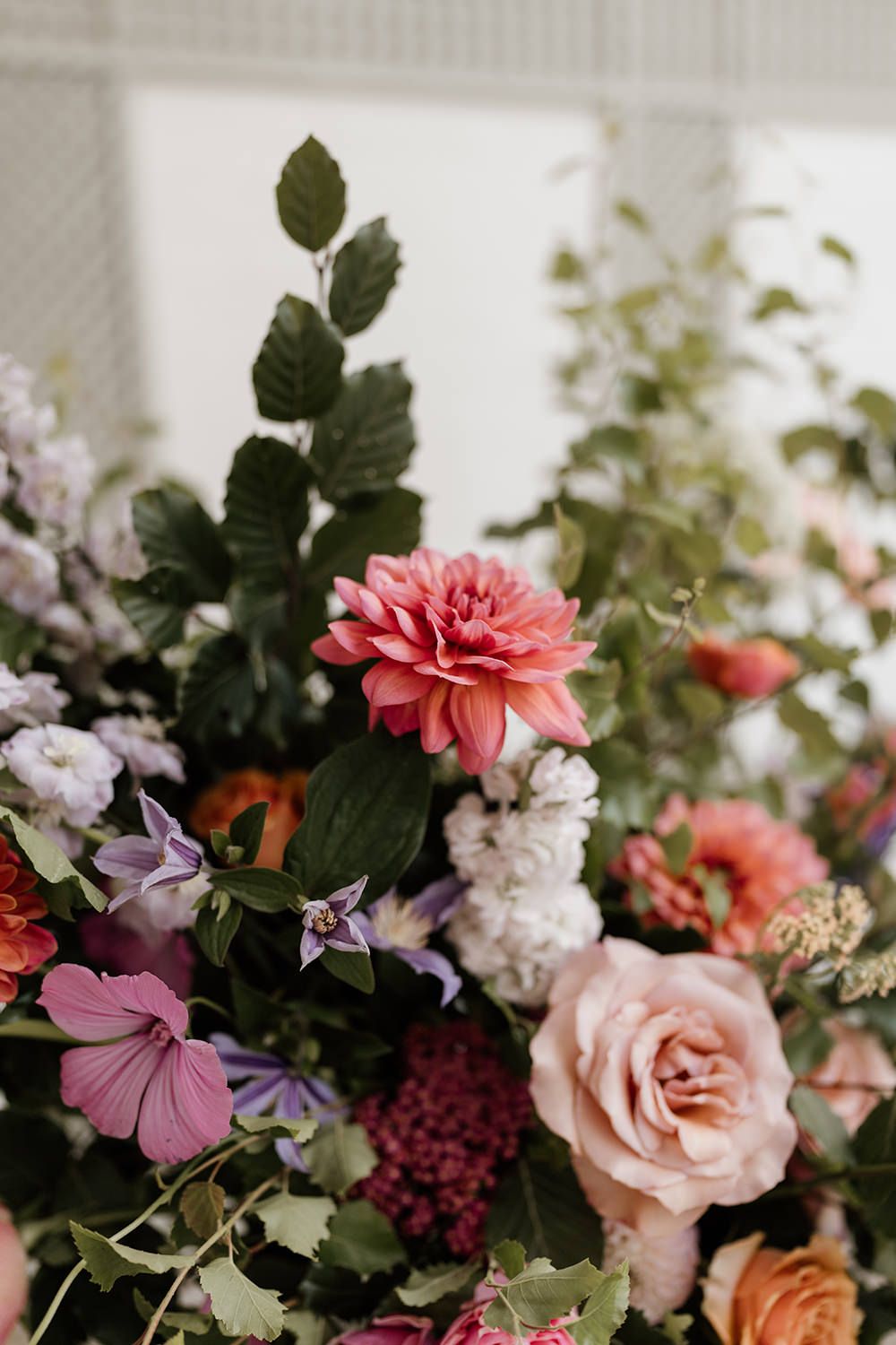 Editorial-style close-up of the bride’s wedding flowers amidst the lush greenery of Kin House’s gardens.