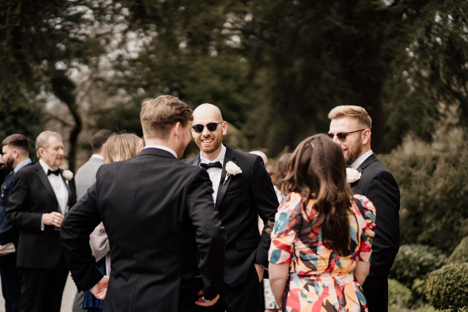 Guests talking to eachother with greenery in the background.