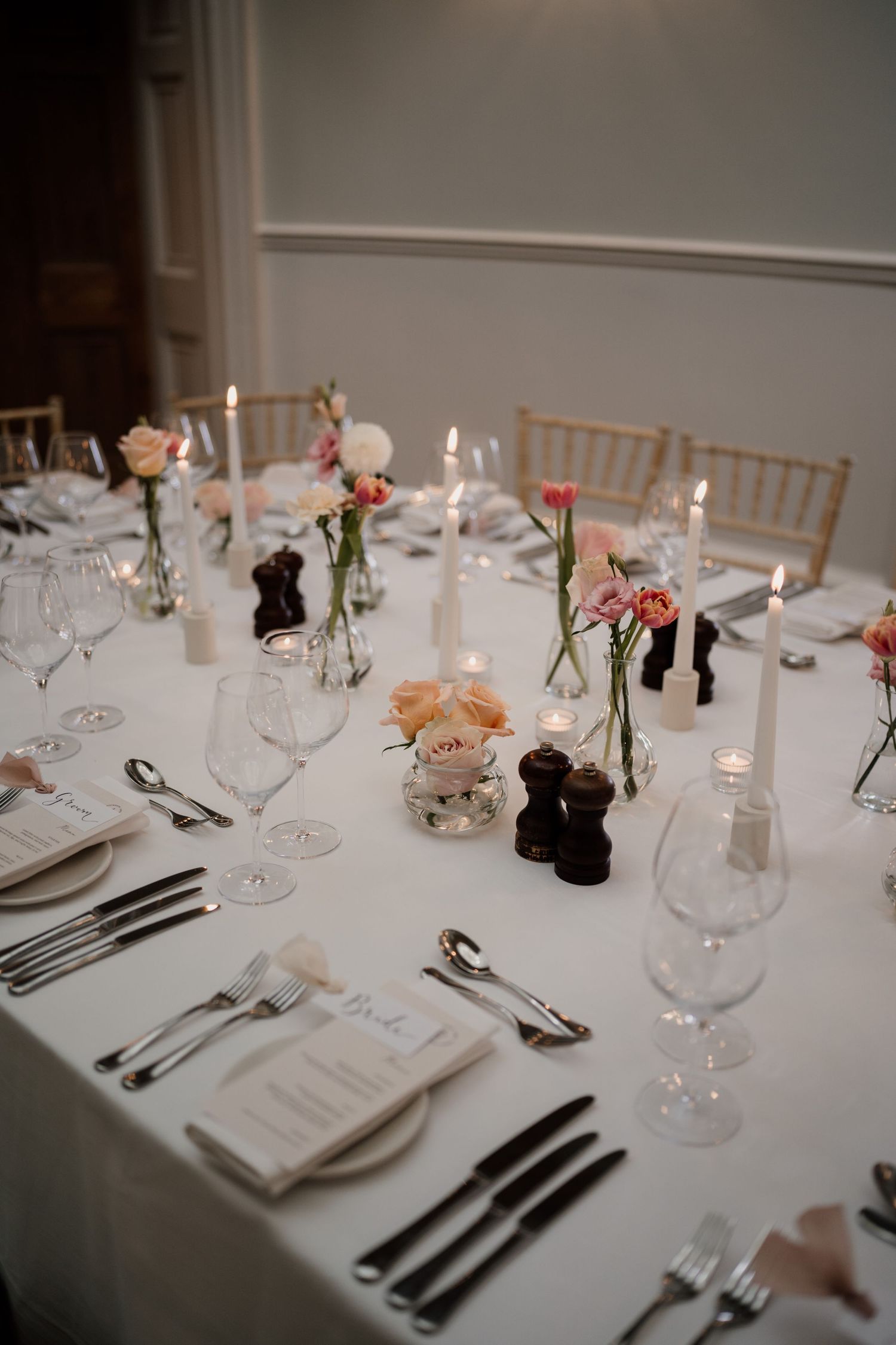 Wedding table styled with candles and florals, lit by candlelight.