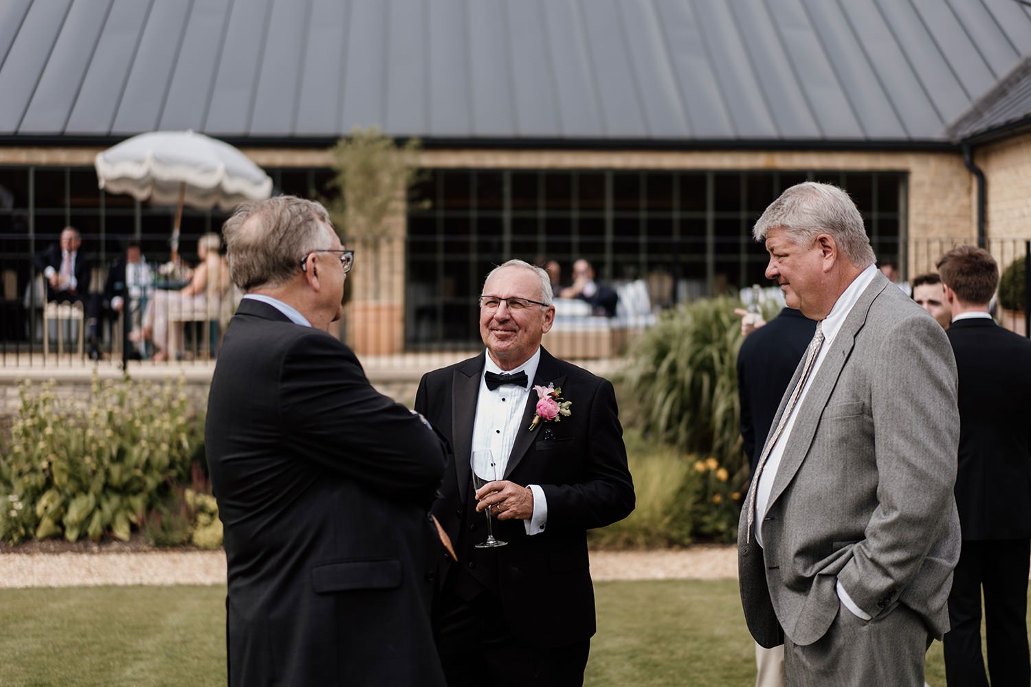 Candid wedding photography: guests enjoying cocktails on the lawn at Kin House.