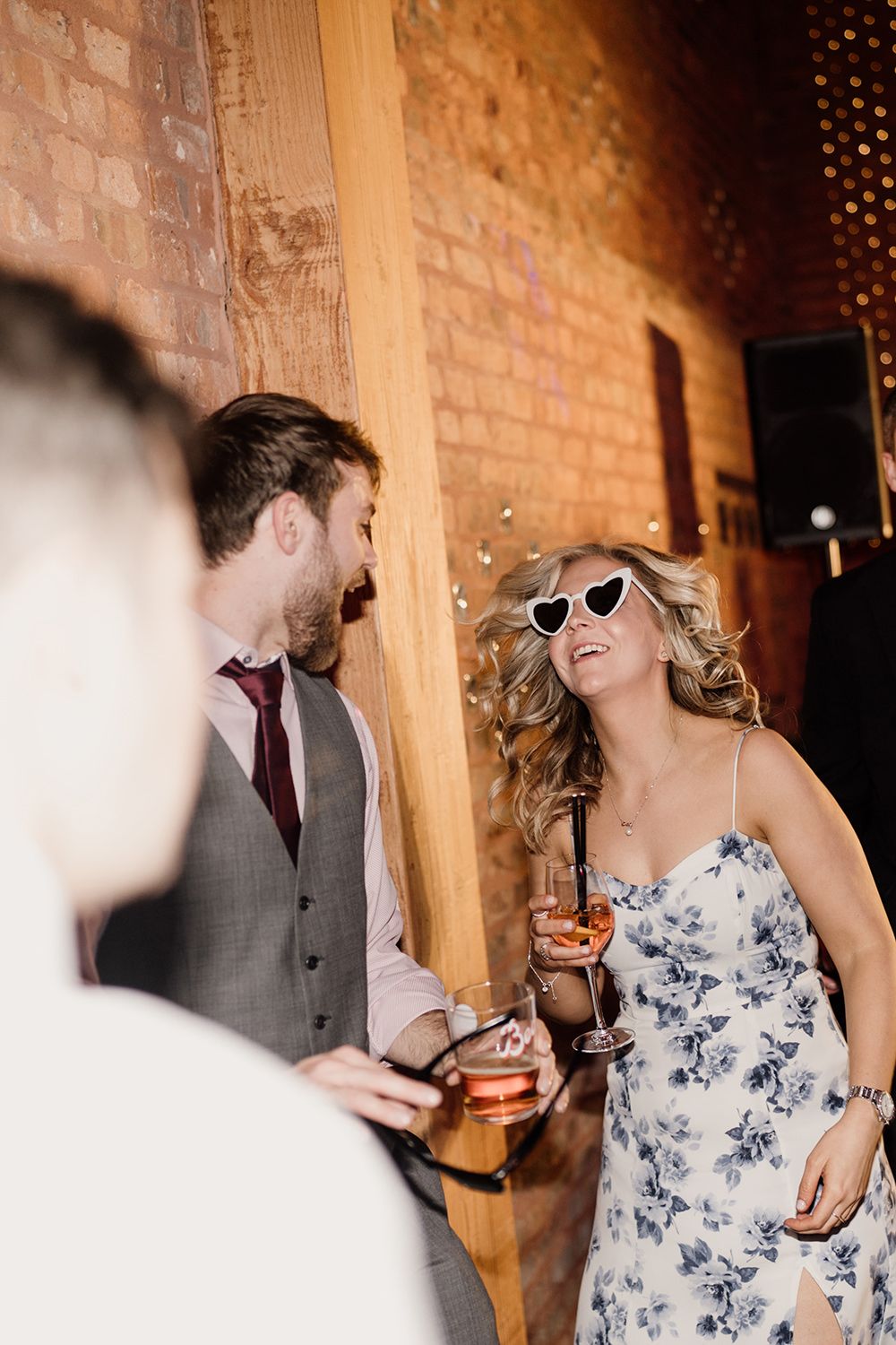 Wedding guests dancing while wearing white sunglasses.