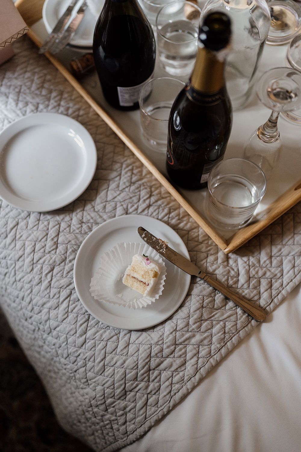 Fondant fancie on plate cut open with champagne bottles around it.
