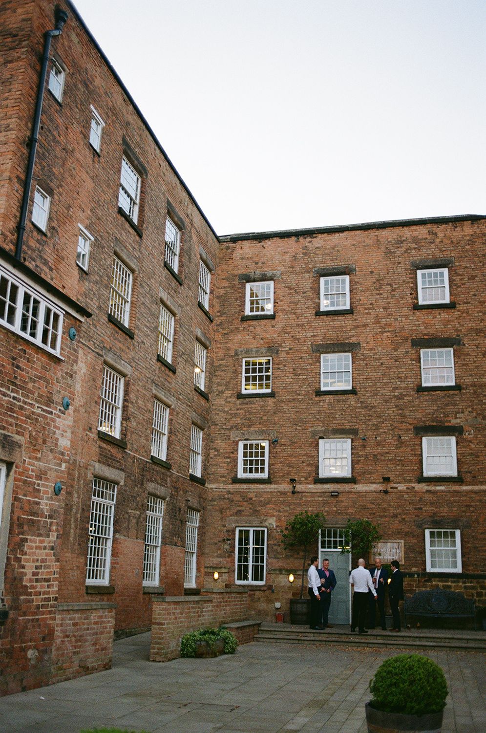 Wedding guests relaxing outside of The West Mill.