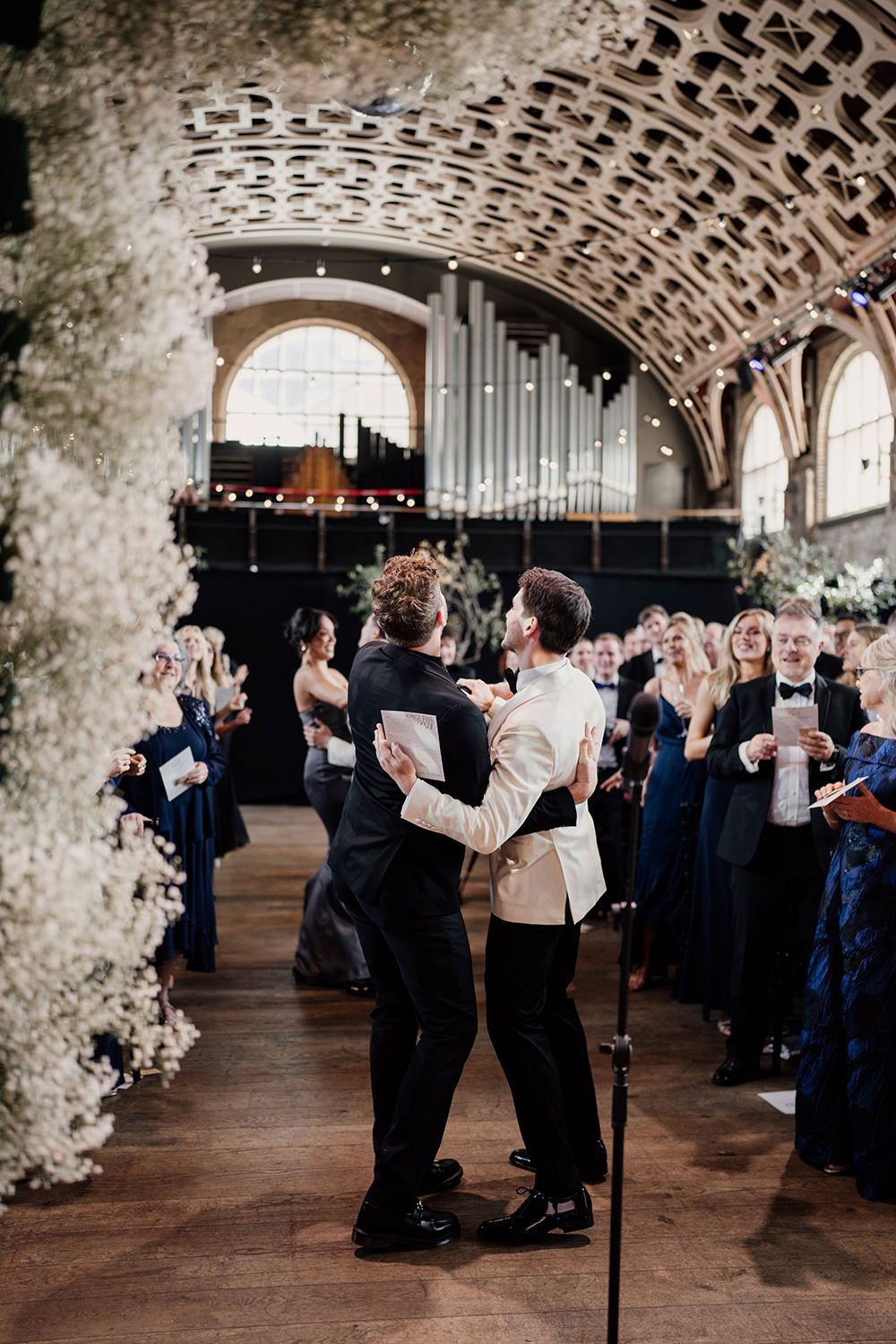 Groom and a guest dancing to the wedding guests during the ceremony.