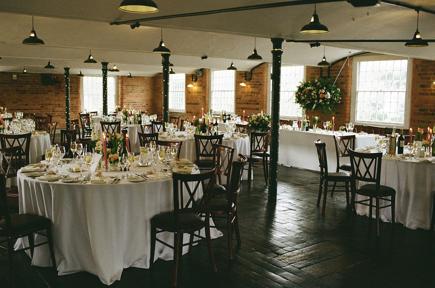 Wedding reception room at The West Mill styled with pastel wild flowers.