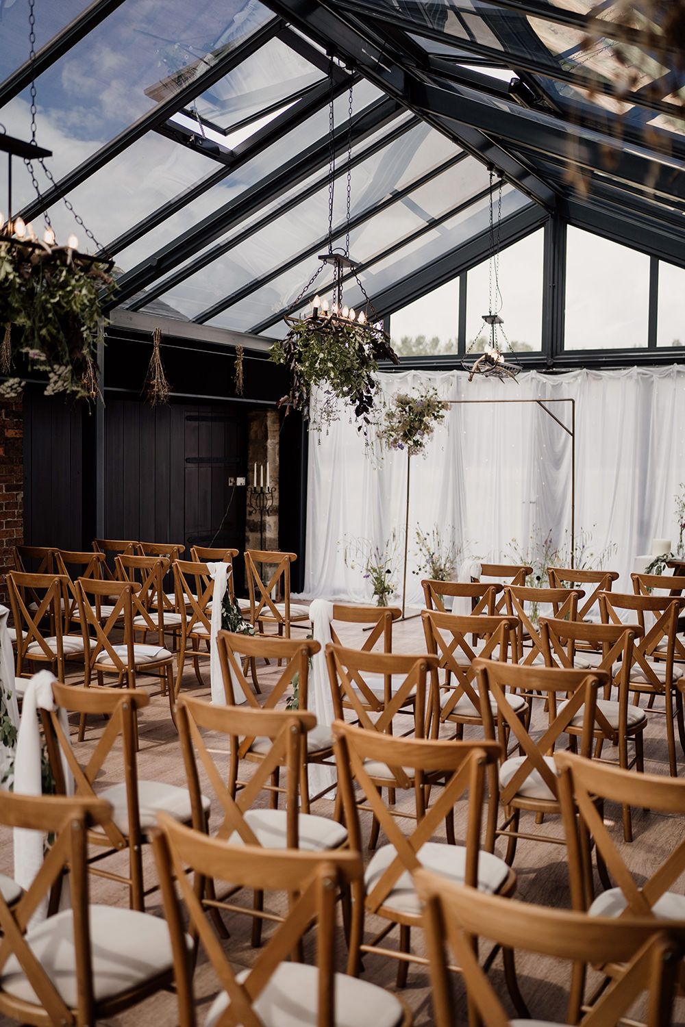 The Hovels Harewood with wooden chairs and a floral arch ready for the bride, groom and guests.