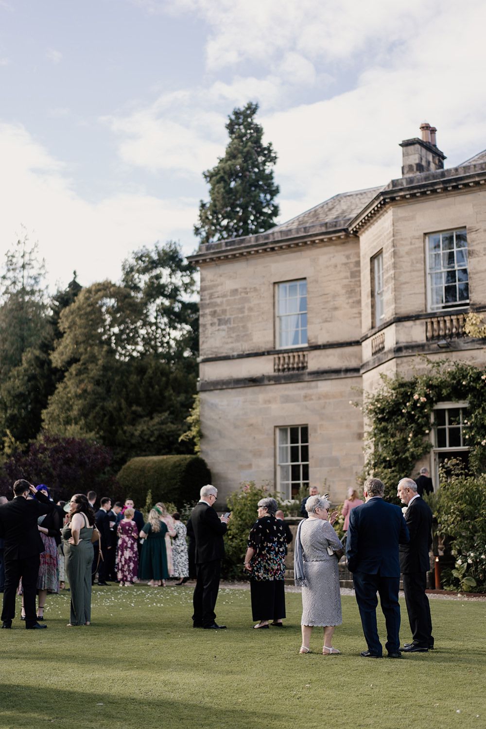 Guests laughing and mingling at the outdoor drinks reception at Middleton Lodge Estate.
