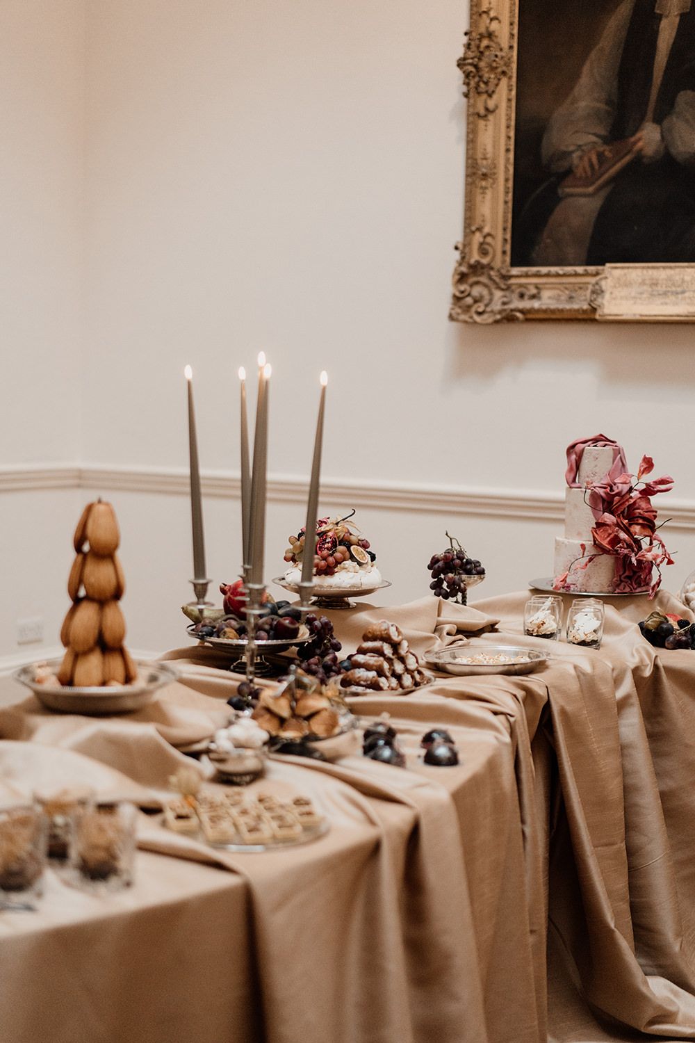 Extravagant dessert table filled with cakes, pastries and candles in the dining room at Rise Hall.