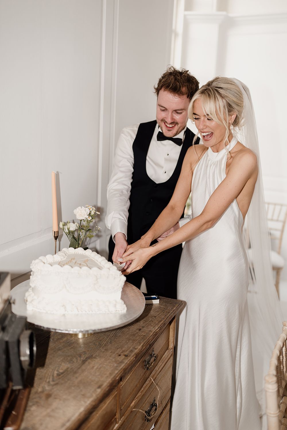 Bride and groom cutting their vintage wedding cake at The Secret Tower, captured by an editorial wedding photographer.
