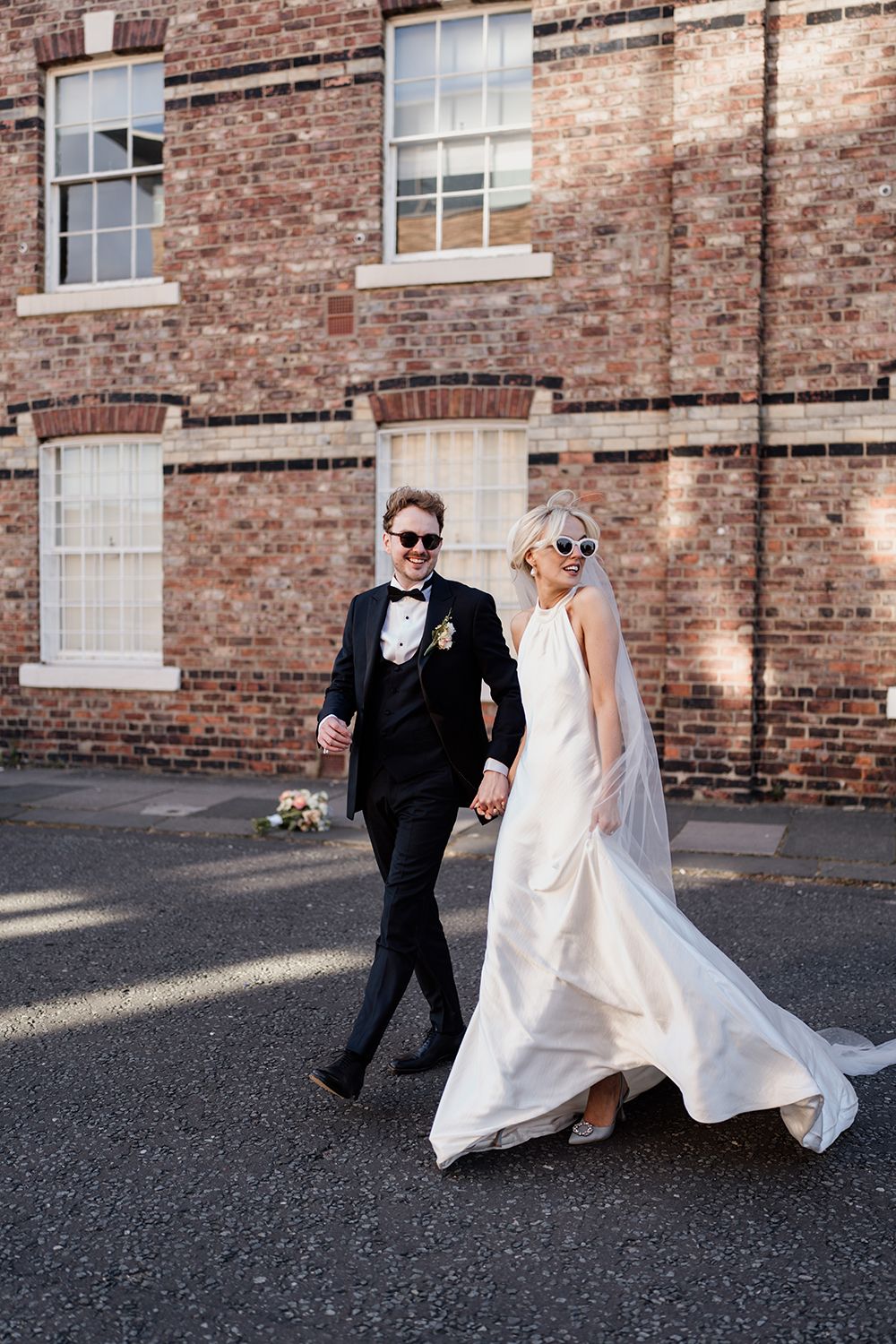 Candid wedding photography: Bride and groom in The Secret Tower's stylish courtyard.