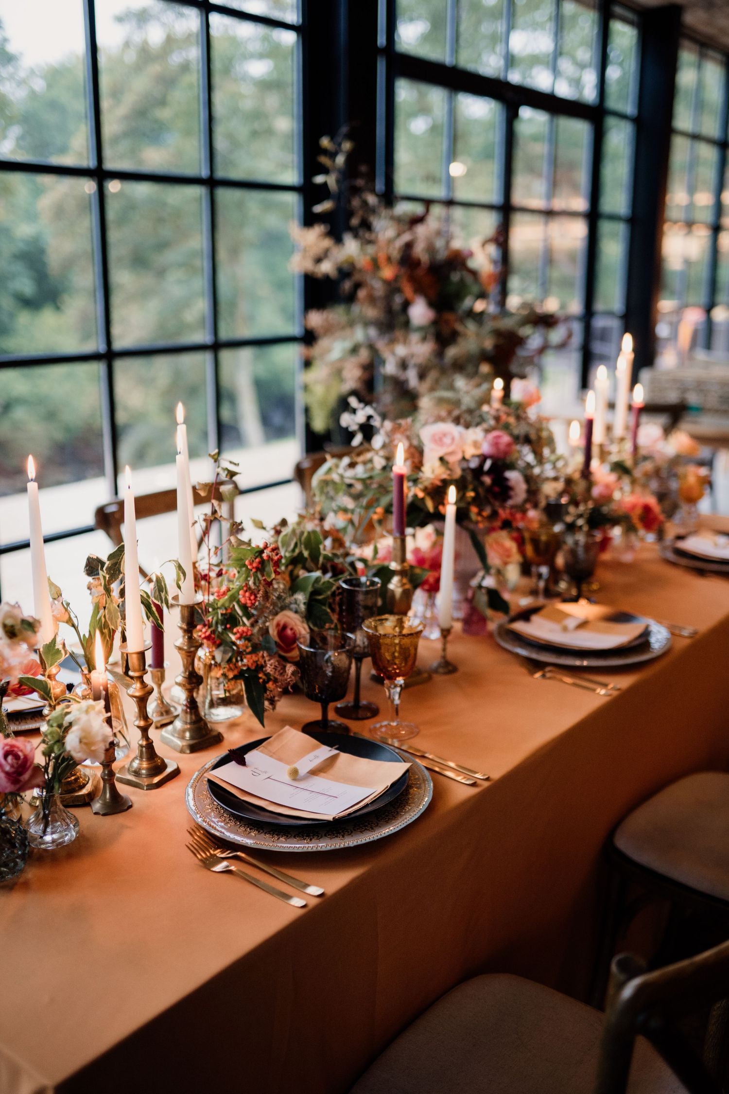 Wedding table styled in autumnal colours, fabrics and rust coloured florals.