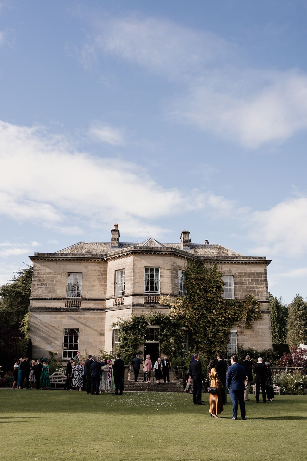 Guests laughing and mingling at the outdoor drinks reception at Middleton Lodge Estate.