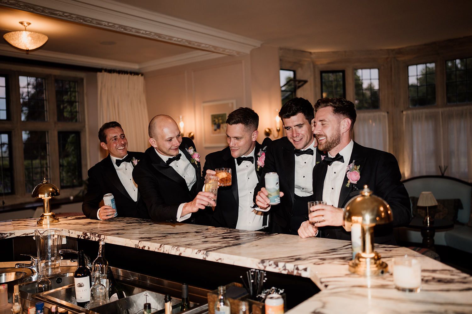 Wedding guests gather around tables illuminated by candlelight during an elegant evening reception celebration.