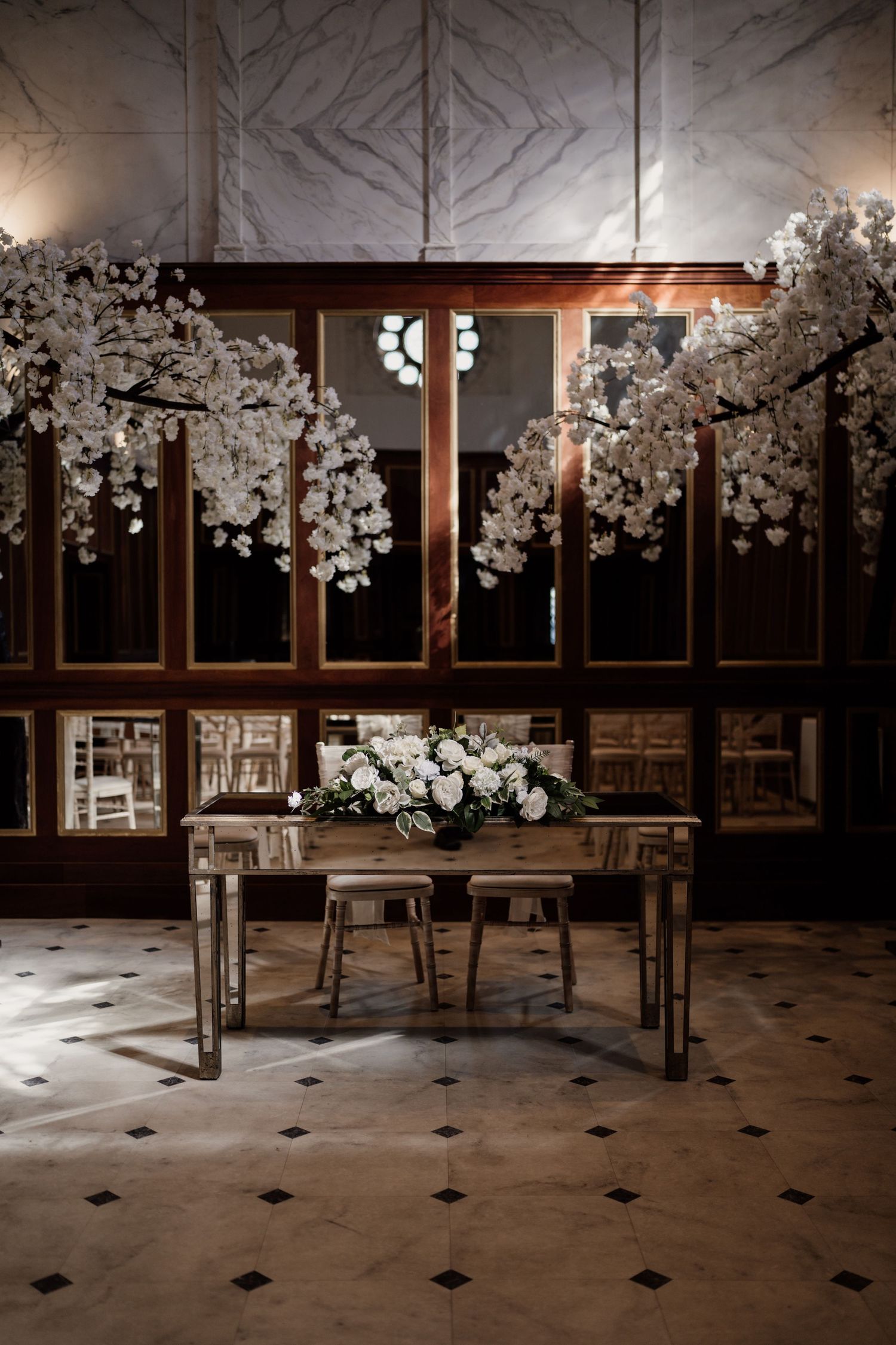 Ceremony room at Boughton Hall with sun through the window styled with white trees.