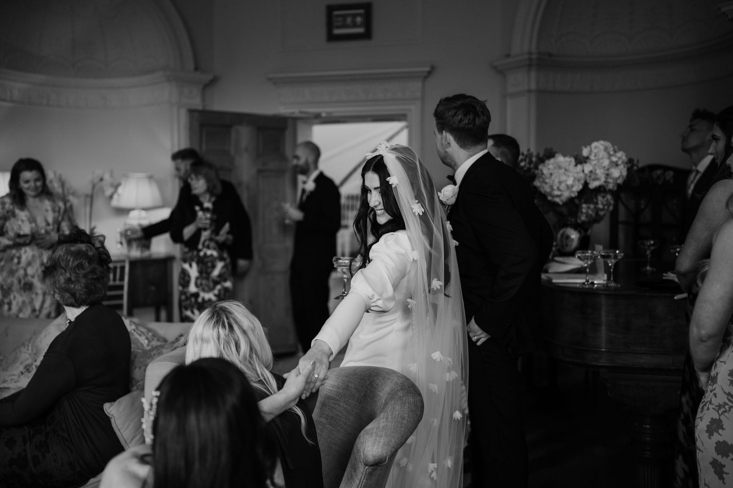 Bride holding hands with a friend during speeches at Middleton Lodge Estate.