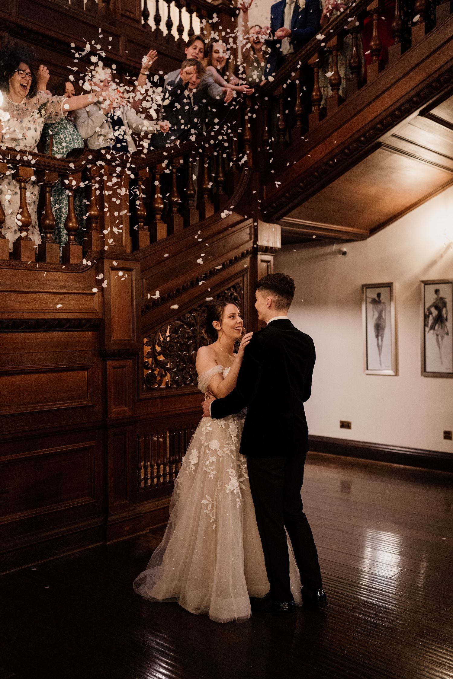 Bride and grooms first dance while family throw confetti around them at Bourton Hall.