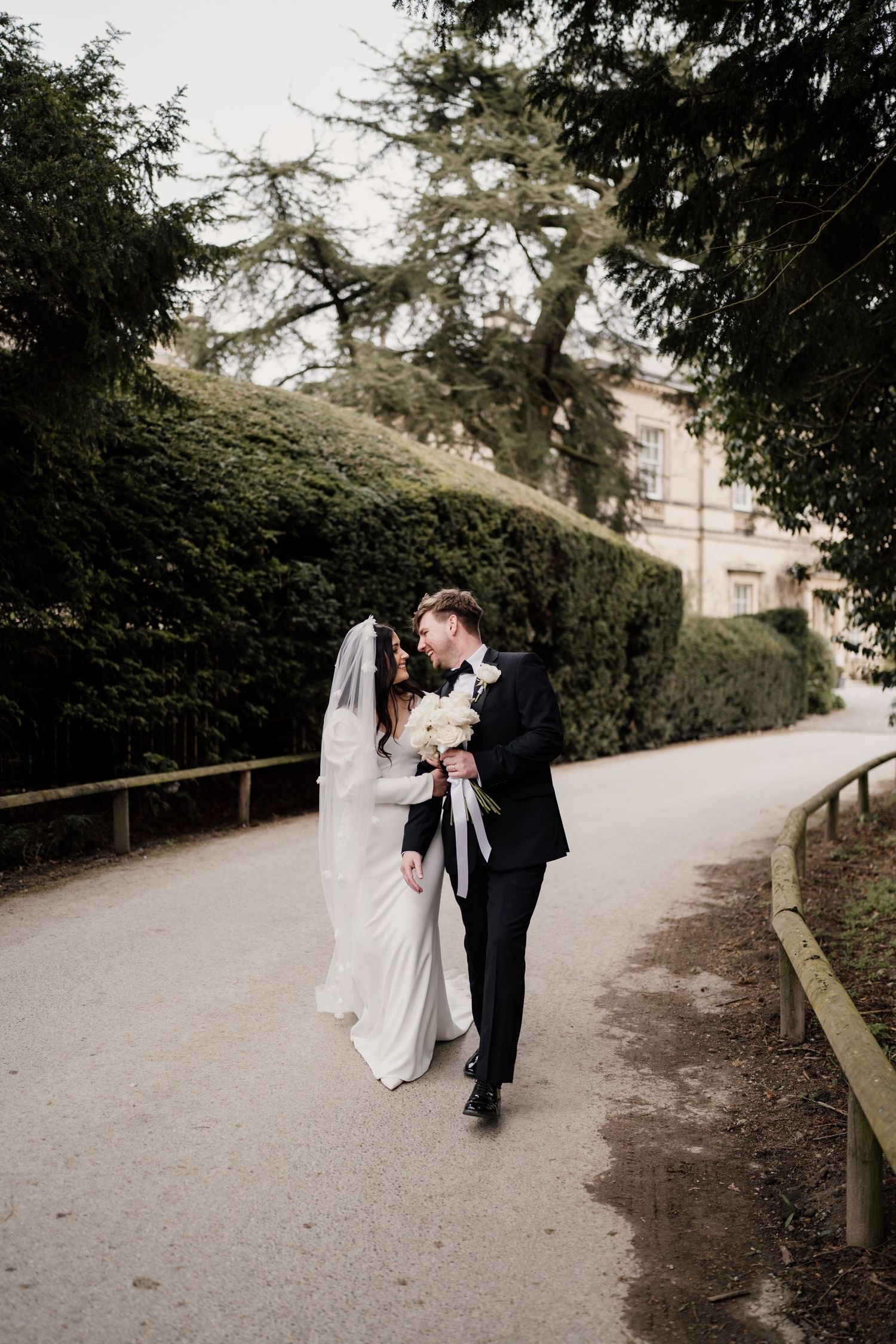 Bride and groom walking and looking towards each-other at middleton lodge.