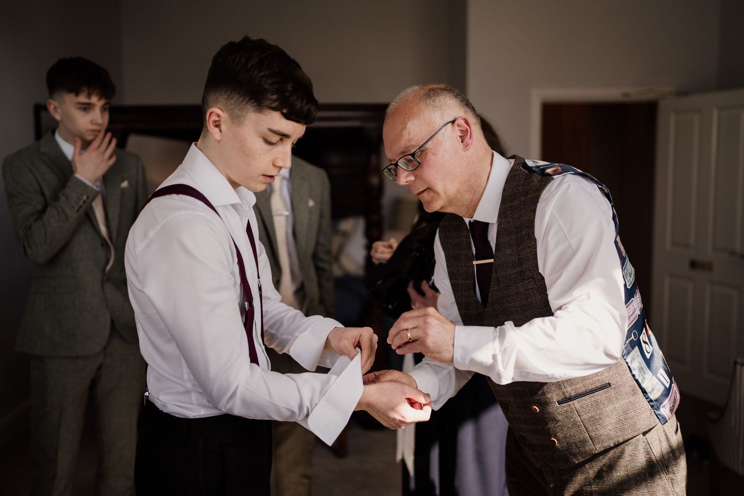 Dad helping his son do his cufflinks on his wedding day.