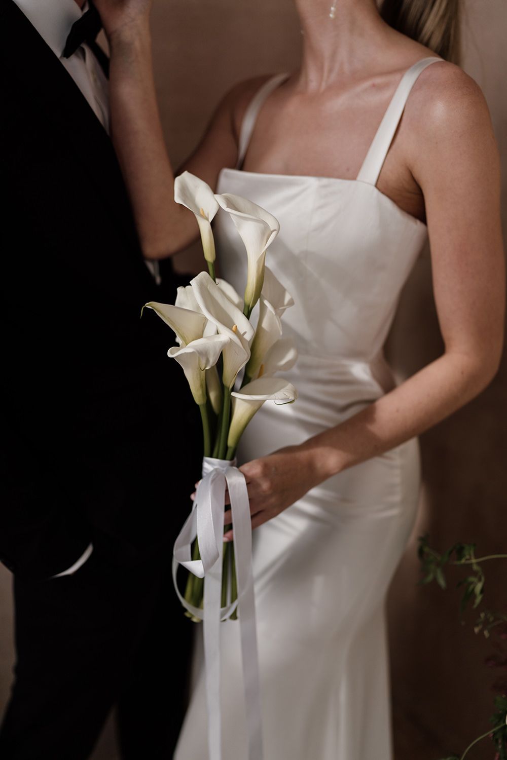 Close up photograph of a couple holding minimal wedding bouquet.