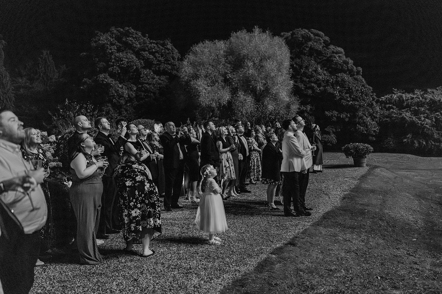 Grooms and guests watch firework display on their wedding evening at luxury UK wedding venue Middleton Lodge.