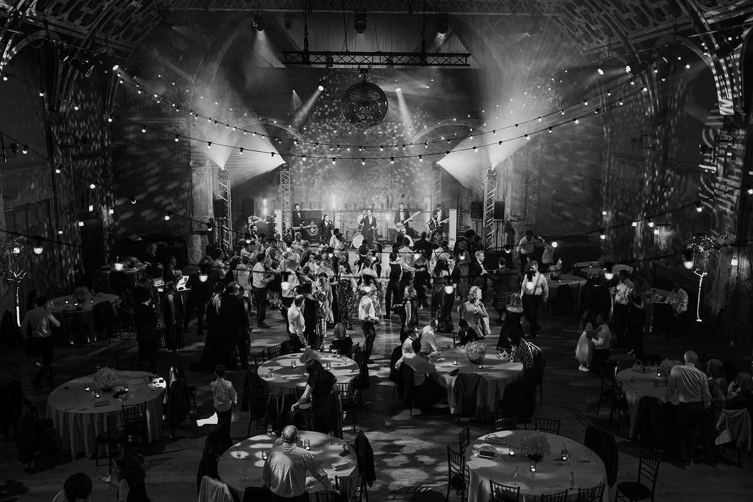 Photograph from above of guests talking and dancing during a wedding day at Battersea Arts Centre.