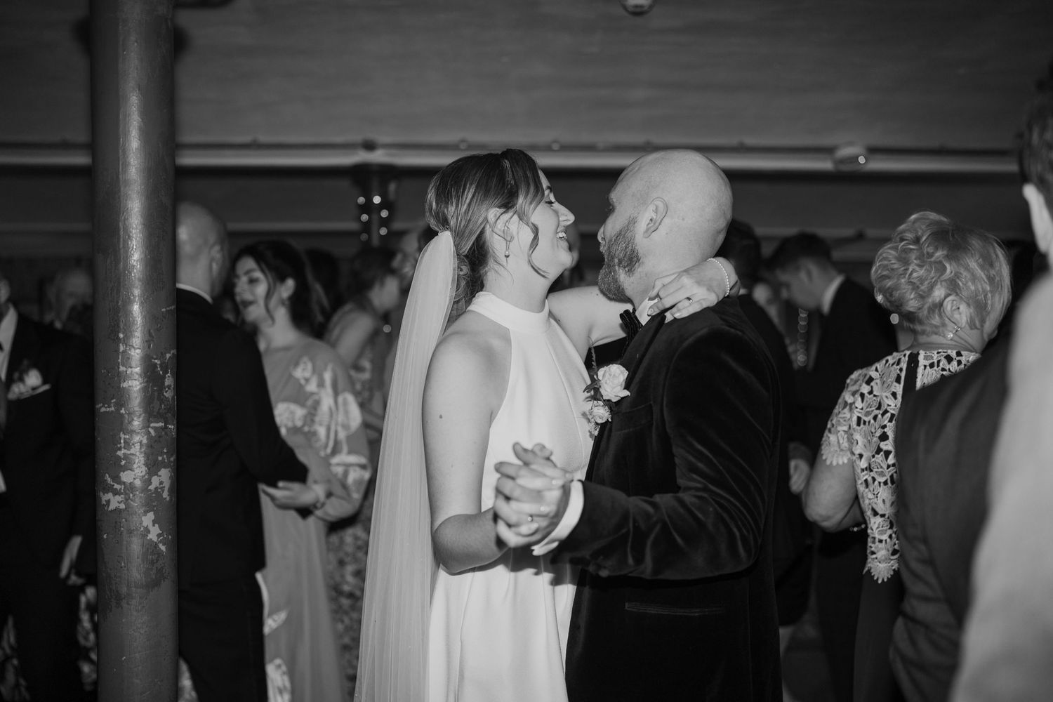 Black and white photo of couple sharing romantic dance at wedding reception.