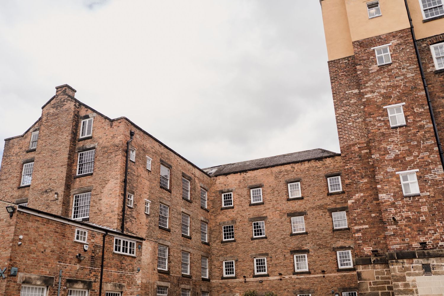 Exterior view of historic brick building with multiple windows and tower.