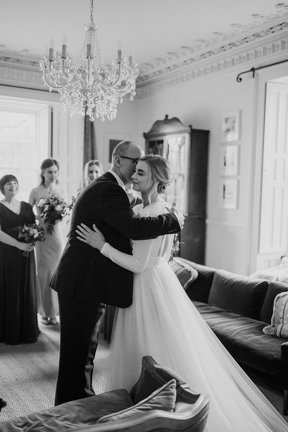 Bride hugging her father as she finishes getting ready on her wedding morning.
