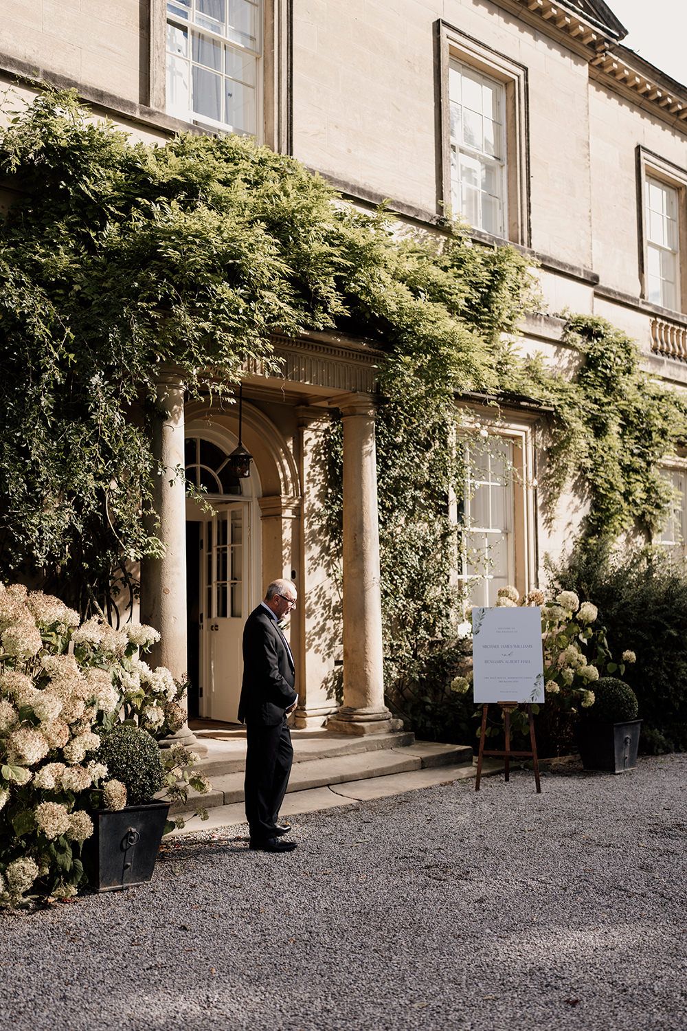 Wedding guest waiting outside of The Main House at Middleton Lodge to greet guests into the wedding ceremony.
