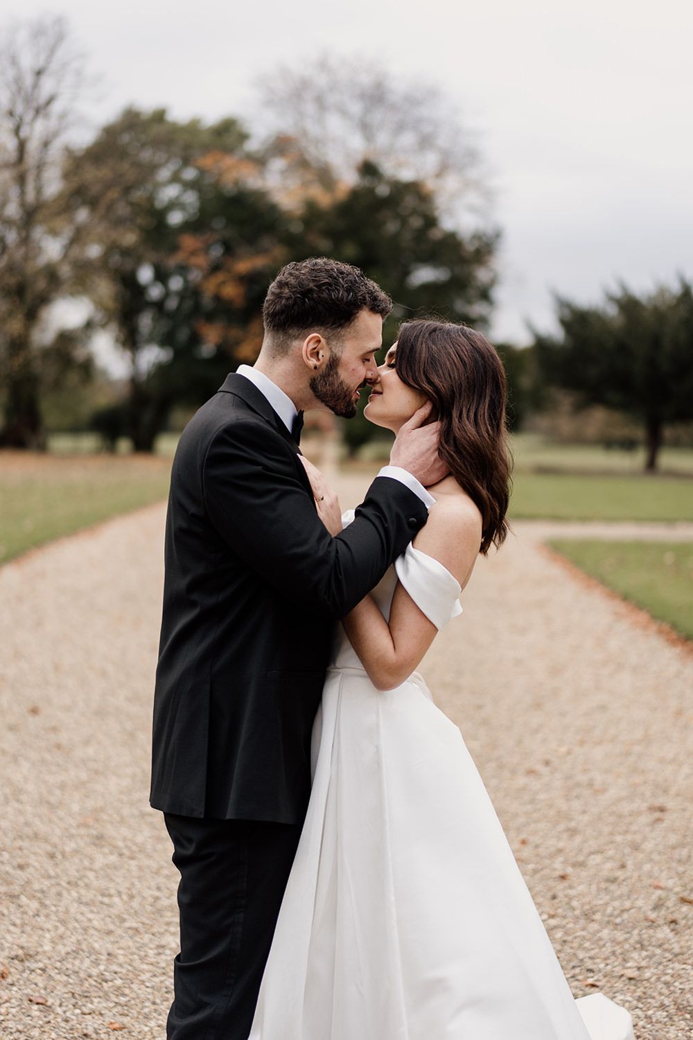 Bride and groom holding hands, smiling, laughing while working through the grounds of Rise Hall.