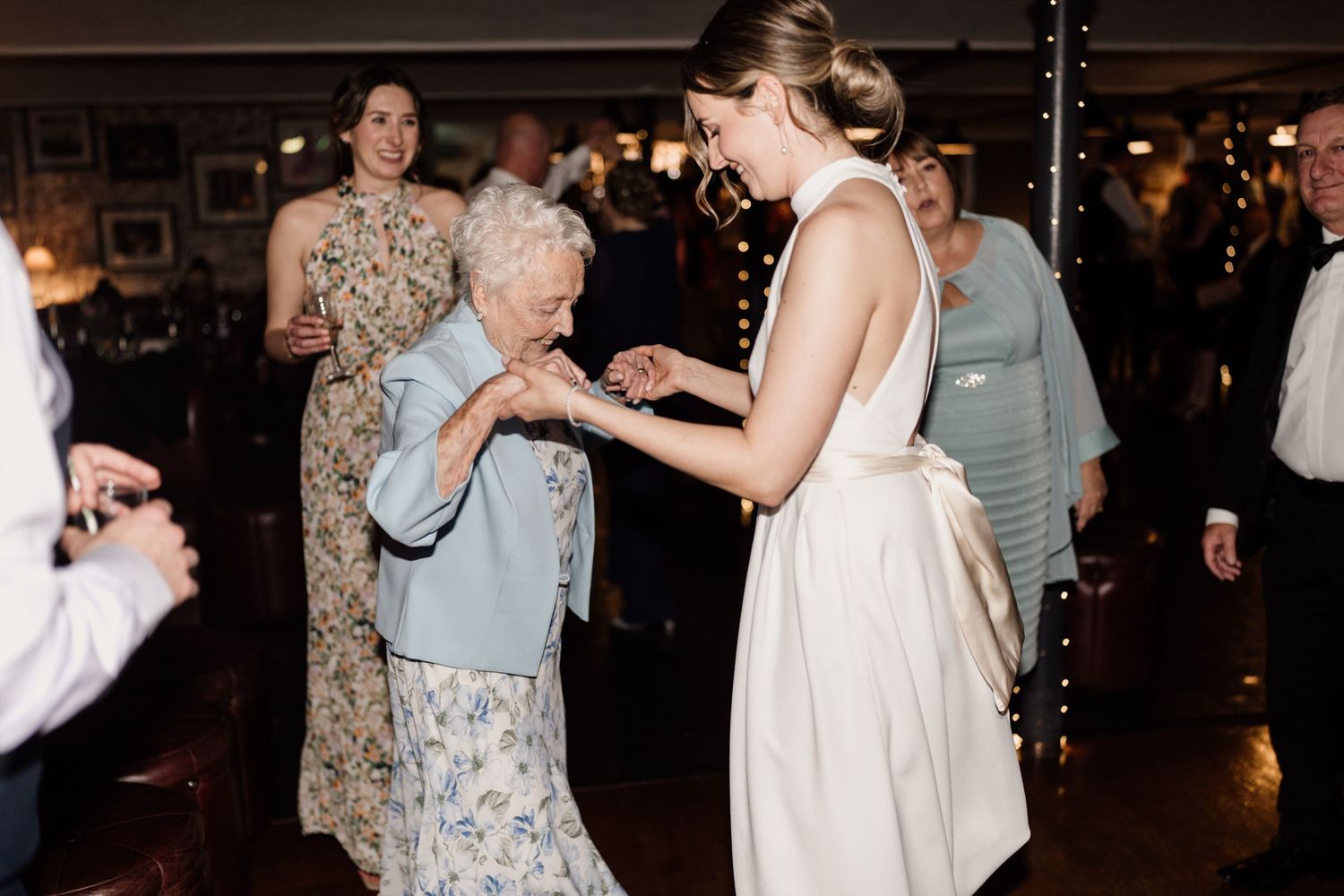 A tender moment of dancing between guests at a wedding celebration.