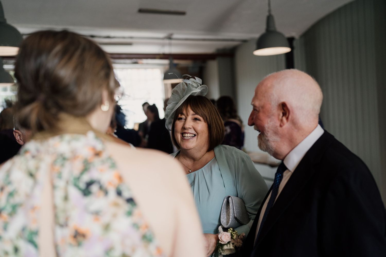 Wedding guests sharing laughter during reception celebration.